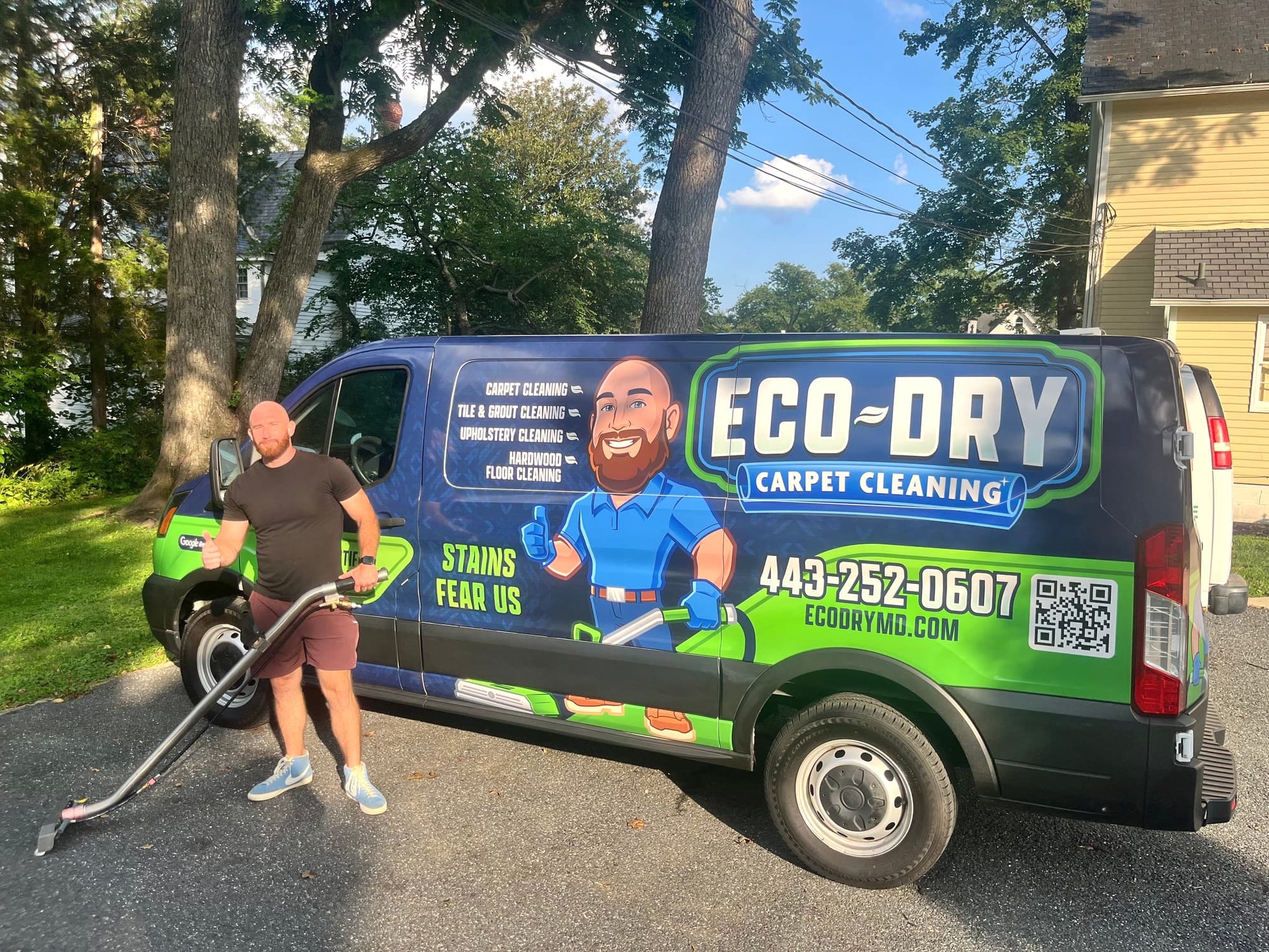Rich holding a cleaning wand beside the new blue and green Eco-Dry van